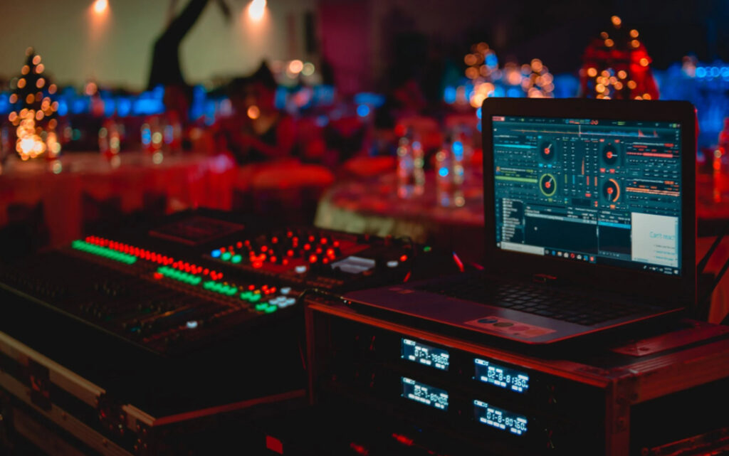 DJ's sound mixing board with laptop at a party